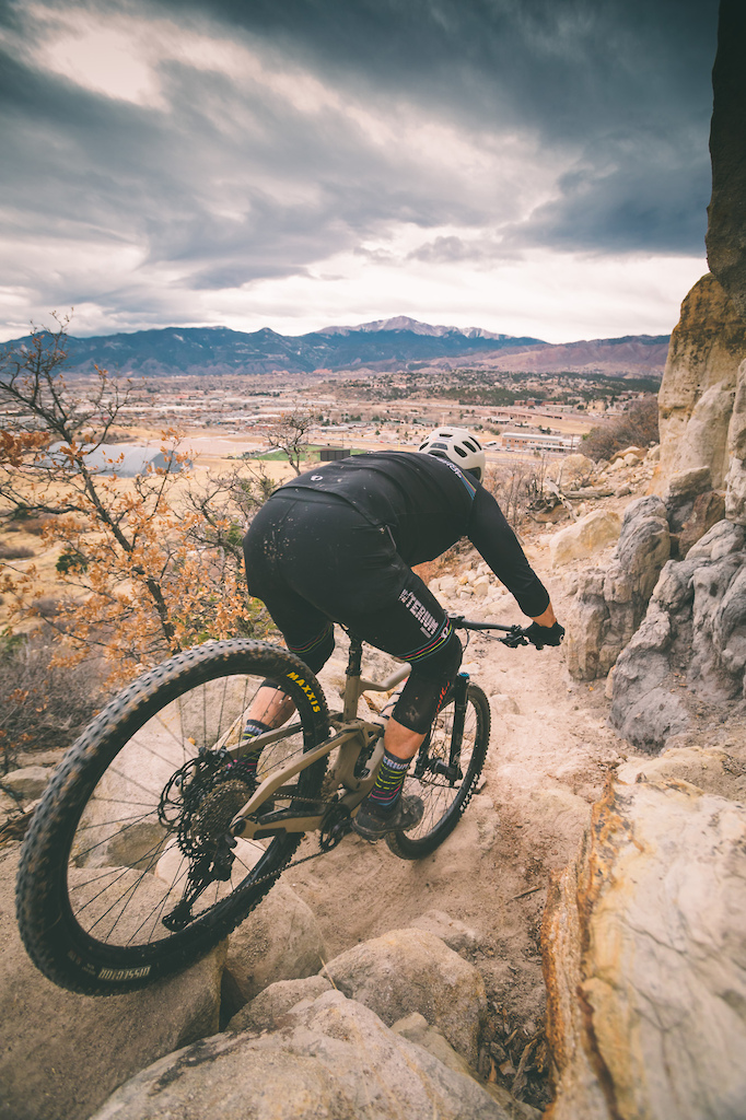 Criterium Bike Shop ambassador Gabe Alverado rides a rocky line on Black Sheep Trail at Austin Bluffs Open Space overlooking Pikes Peak. Austin Bluffs Open Space is located in Colorado Springs.